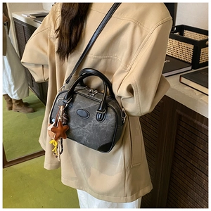 Macro view of vintage grey boston bag with marble texture and star charm on side