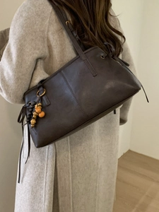 Vintage dark brown leather shoulder bag with drawstring detail and wooden bead pendant
