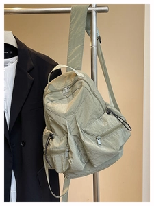 Detail of sage green crinkle nylon backpack with adjustable drawstring side pockets