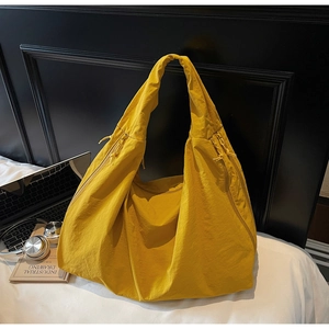 Gros plan sur le grand sac cabas jaune avec tissu en nylon texturé et détail de fermeture éclair