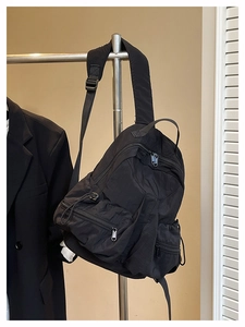 Detail of black nylon sports backpack with multiple zipper compartments and adjustable straps