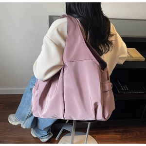Gros plan du sac cabas en nylon vieux rose avec large bandoulière et poches latérales