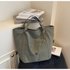 Detail of sage green canvas tote bag featuring high-density fabric and dual handles