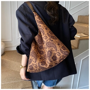 Detail of vintage paisley pattern on a large canvas tote bag with brown straps