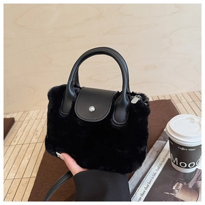 Detail of black plush bucket bag showing faux fur texture and silver metal snap button