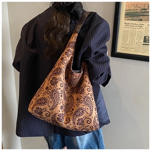 Detailed view of paisley pattern canvas tote bag styled with navy striped suit