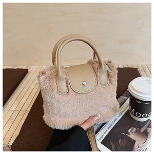 Detail of soft beige faux fur handbag with PU leather handle and silver magnetic buckle