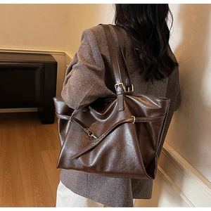 Macro shot of dark brown tote bag with vintage texture and metallic buckle detailing