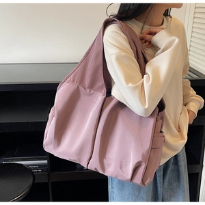 Détail d'un sac cabas en nylon rose poudré avec poches latérales et large bandoulière