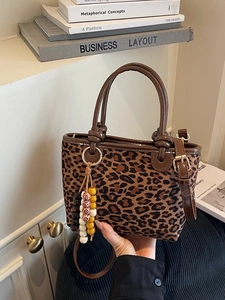 Secchiello chic con stampa leopardata, manici in pelle marrone e ciondolo di perline