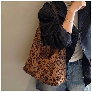 Detail of vintage paisley pattern on a large canvas tote bag styled with a blazer