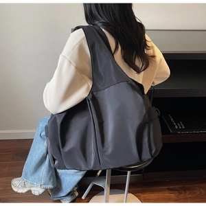 Vue détaillée d'un grand sac cabas noir en nylon porté à l'épaule pour le travail