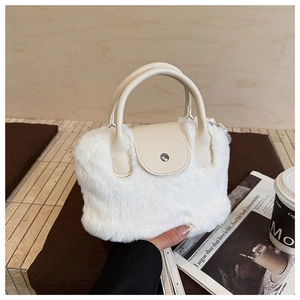 Close-up of white plush faux fur texture and cream leather details on the bucket bag