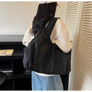 Photo de style de vie du grand sac cabas en nylon noir plissé avec large bandoulière