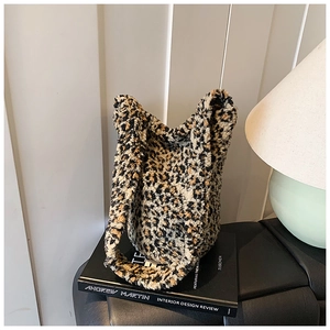 Detail shot of leopard print plush tote bag with soft faux shearling texture on design books