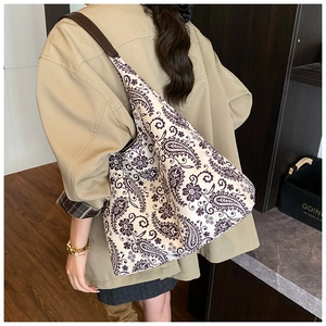 Rear view of a model wearing the large vintage paisley canvas tote bag with leather straps