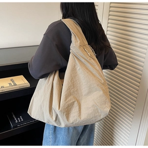 Détail du sac à bandoulière en nylon léger avec fermeture éclair résistante