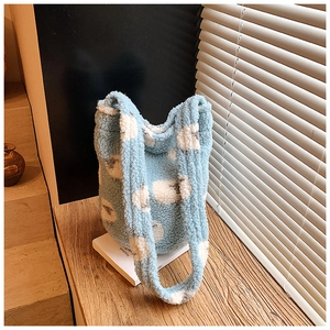 Close-up of light blue plush bucket bag with cloud patterns on a wooden step