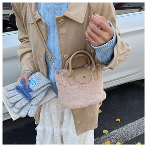 Close-up of pink faux fur bucket bag with leather handle and silver magnetic metal clasp