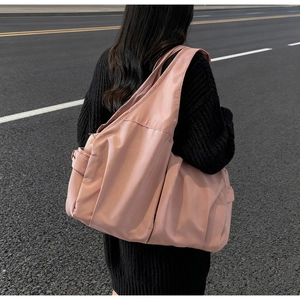 Détail du grand sac cabas rose avec poche latérale et texture en nylon imperméable