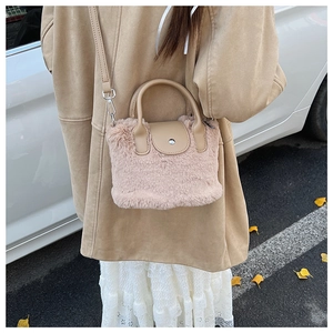Detail of plush faux fur handbag with leather handles and metallic magnetic closure
