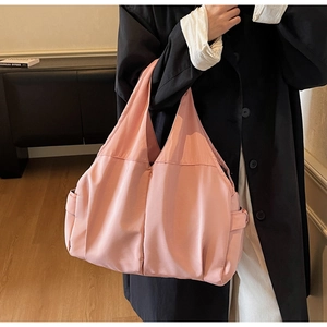 Détail du grand sac cabas en toile rose avec poche latérale porté par un mannequin
