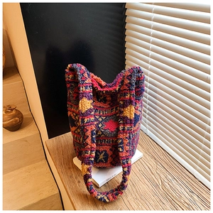 Detail of ethnic pattern fleece bucket bag with geometric texture on wood table