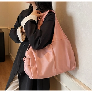 Gros plan du grand sac fourre-tout rose en nylon avec large bandoulière pour un look décontracté