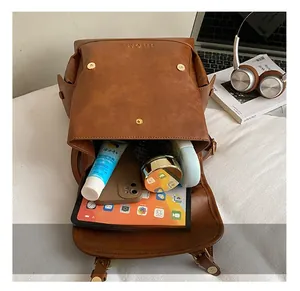 Spacious interior of brown faux leather backpack showing storage for tablet and essentials