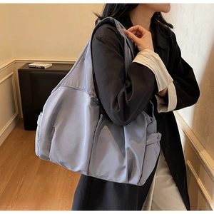 Vue détaillée du grand cabas en nylon bleu clair avec poche latérale et tissu durable