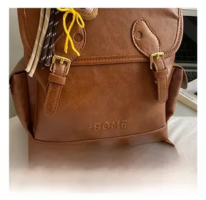 Close-up of retro brown PU leather backpack with vintage hardware and tassel detail
