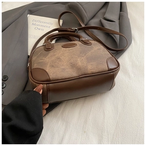 Detailed close-up of retro brown Boston bag with mixed fabric and leather textures