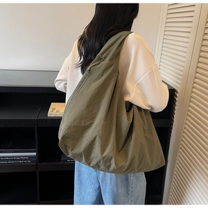 Détail du sac fourre-tout en nylon olive avec cordon latéral et bandoulière large
