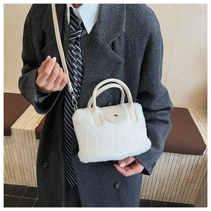 Model wearing white faux fur bucket bag with beige handle and stylish grey wool coat
