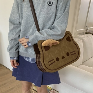 Detailed view of a brown cat crossbody bag with plaid trim and a cute plush animal charm