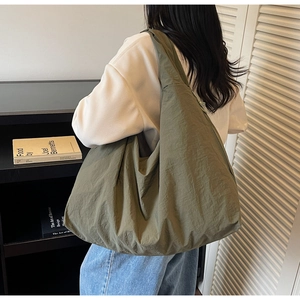 Détail du grand sac cabas en nylon vert olive avec texture plissée pour le quotidien