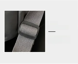 Detail view of adjustable plastic buckle and durable grey woven strap on the travel bag