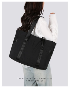 Grand sac fourre-tout noir matelassé avec sangles renforcées porté par un mannequin