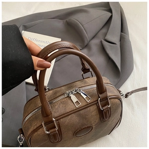 Top view of vintage brown boston bag with dual silver zippers and textured material