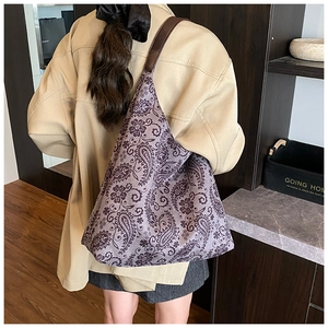 Detail of bohemian purple tote bag with paisley floral pattern on casual model