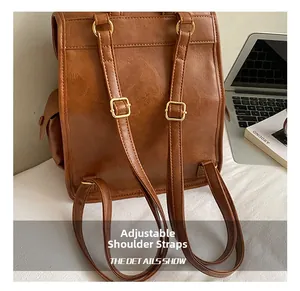 Detail showing adjustable brown leather straps with gold metal buckles on a vintage backpack