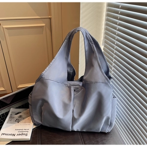Vue détaillée du grand sac cabas bleu clair avec bandoulière large et poche latérale