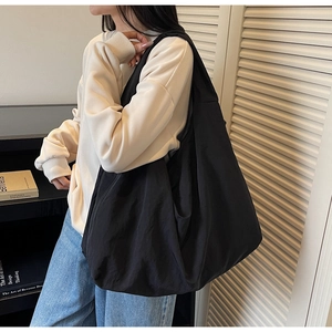 Détail du sac hobo en nylon noir minimaliste montrant sa texture légère et sa grande capacité