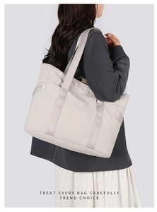 Détail du cabas en nylon blanc cassé montrant les larges sangles et la texture plissée