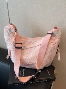 Pink quilted canvas crossbody bag with butterfly embroidery and adjustable strap