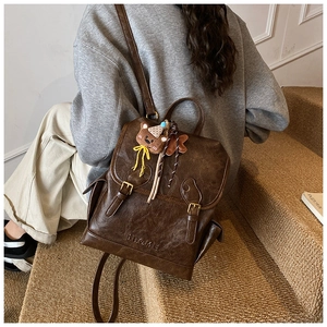 Deep brown vintage backpack detail with cute bear pendant and bowknot accessory