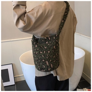 Vue arrière d'un grand sac cabas en peluche à motif léopard porté à l'épaule par un mannequin