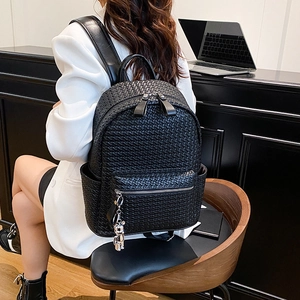 Women's black woven faux leather backpack with silver bear charm and front zipper pocket
