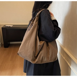 Détail du sac fourre-tout en nylon plissé kaki foncé montrant la texture et la grande capacité