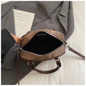 Internal view showing black fabric lining and zipper closure of the retro brown handbag
